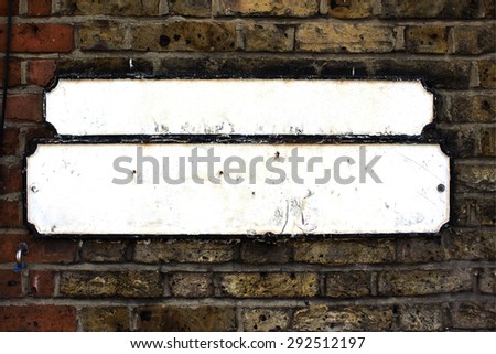 Blank white British street sign on brick wall
