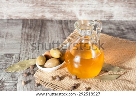 olive oil and olives on a rustic wooden background