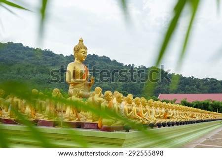 Buddha statue and bamboo leaves foreground blur in Thailand