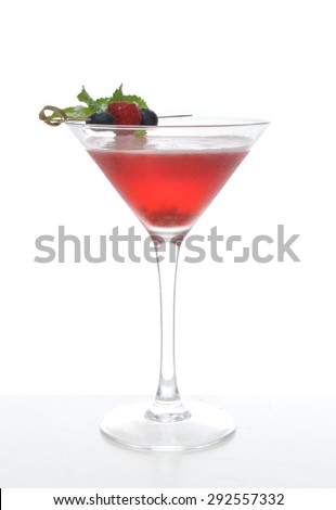 Red alcohol cosmopolitan cocktail decorated with mint blueberry and raspberry in martini cocktails glass on a white background