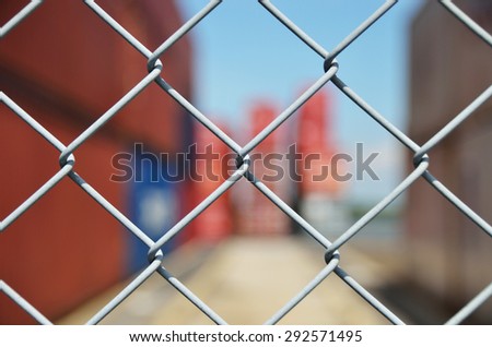 Wire mesh fence enclosing the container yard Royalty-Free Stock Photo #292571495
