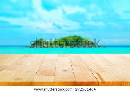 Wood table top on blur  island background - can be used for montage or display your products