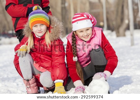 Children in winter park having fun and playing snowballs