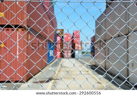 Wire mesh fence enclosing the container yard Royalty-Free Stock Photo #292600556