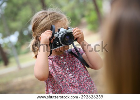 Portrait of little girl taking picture of her parents 