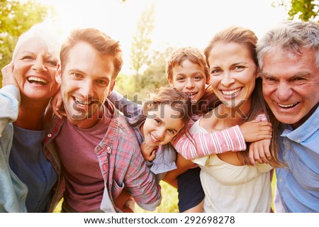 Multi-generation family having fun together outdoors Royalty-Free Stock Photo #292698278