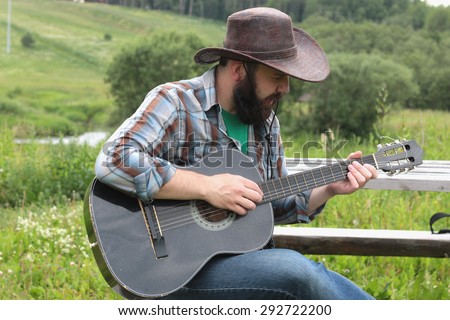 guitarist in a cowboy hat on the nature