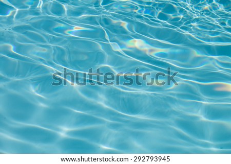 Surface of water on the swimming pool reflecting the sun