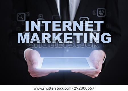 Businessman holding a tablet pc with "Internet marketing" text on virtual screen. Internet concept. Business concept.