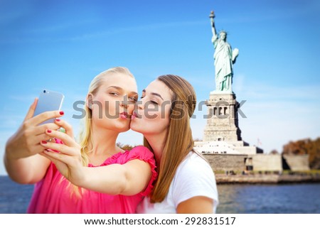 Two girls making a self portrait in New York. In Background the statue of liberty