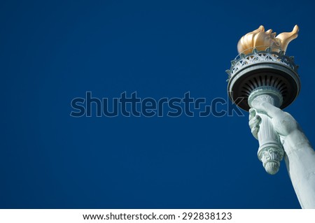 Statue of Liberty close-up torch against bright blue American sky