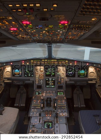 Airbus A330 airplane's cockpit with front,overhead and pedestrian panel taken on ground at dusk with concrete pavement in background.  Royalty-Free Stock Photo #292852454