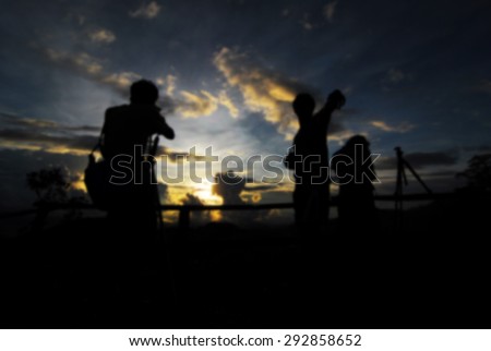 silhouette of blur photographer taking picture of landscape during sunrise