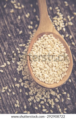 Vintage Dried Sesame Seeds in Wooden Spoon on Rustic Wooden Background. Super Still Life Photography. Organic Food and Healthy Lifestyle image. Retro Filter used.