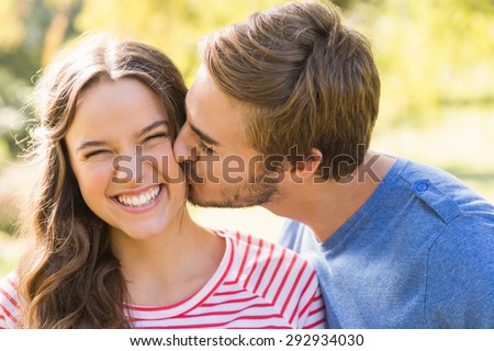 Cute couple kissing in the park on a sunny day Royalty-Free Stock Photo #292934030