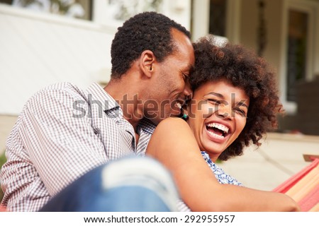 Laughing couple cuddling in a hammock Royalty-Free Stock Photo #292955957