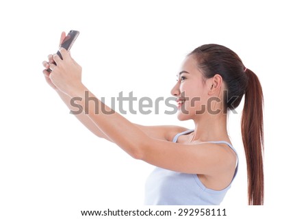 Happy asian woman taking a selfie using her smartphone 