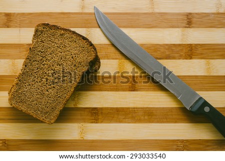 Bread and knife on the wood desk of the home kitchen