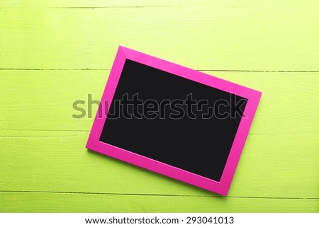 Wooden frame on green wooden background