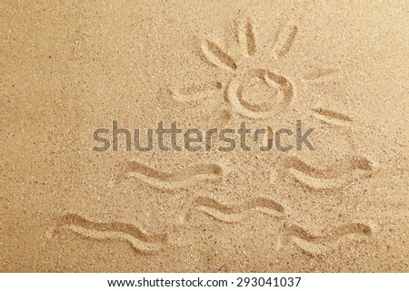 Drawing sun on beach sand