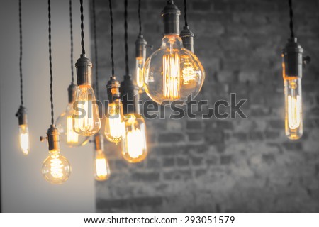 Decorative antique edison style filament light bulbs against brick wall Royalty-Free Stock Photo #293051579
