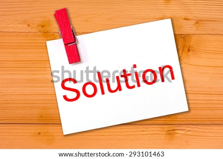 white paper solution text with red wood clip on wooden background,abstract background for solution issue. 