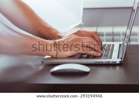 Close up of businessman using computer keyboard at desk in office