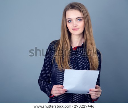 Modern stylish young woman holding a white blank sheet of labels. Ordinary people. Photo model. Portrait of a modern woman. Concept for the placement of the information, there is space for text.