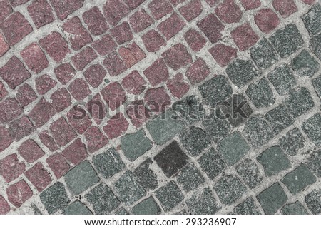 Many-coloured stone background on the basis of natural material. Sidewalk, paved with granite elements.