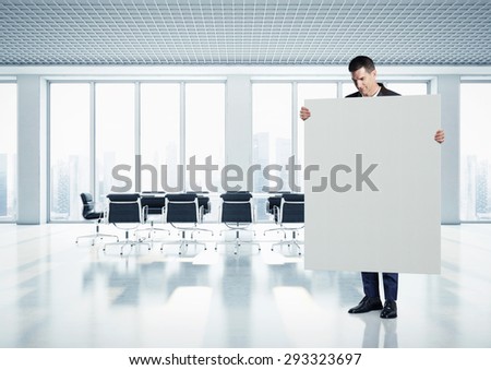 Businessman holding canvas at contemporary office