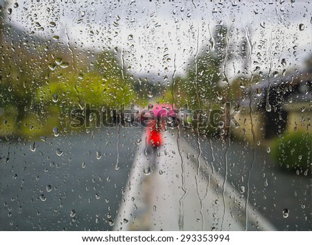 Rain on a window looking out to people in a street scene