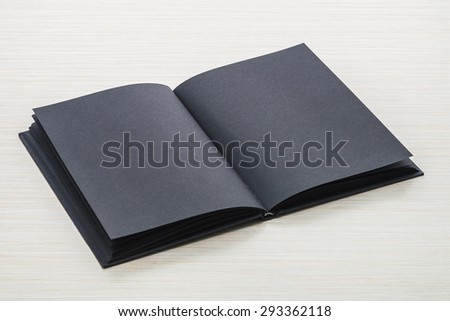 Black notebook on wood background