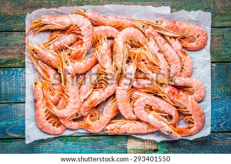 fresh raw prawns on paper on a rustic wooden table