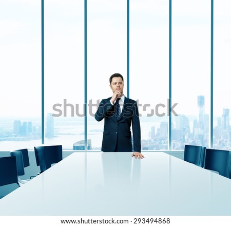 young businessman in suit standing in boardroom