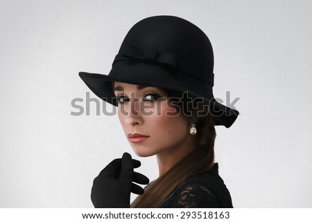 beautiful brunette wearing retro hat on rhe neutral background