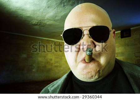 Image of a mobster, gangster, or boss in a dark factory setting. Harsh lighting, high-contrast and cross-processing for meaner look. Royalty-Free Stock Photo #29360344