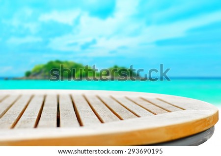 Round wood table top on blur sea and island background - can be used for display or montage your products