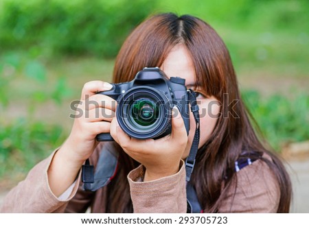 Young women takes pictures with DSLR camera. 