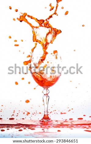 Glass of orange fresh water, Water flows into the glass make splash isolated on a white background, water drop splash on white background