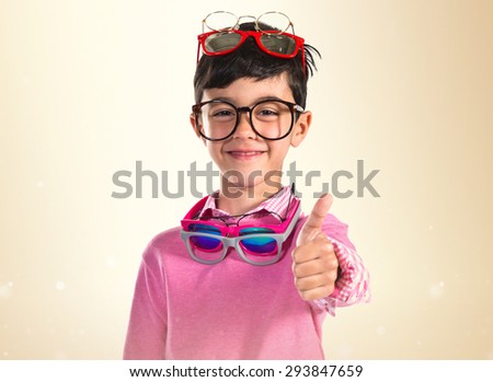 Happy boy with many glasses over ocher background 