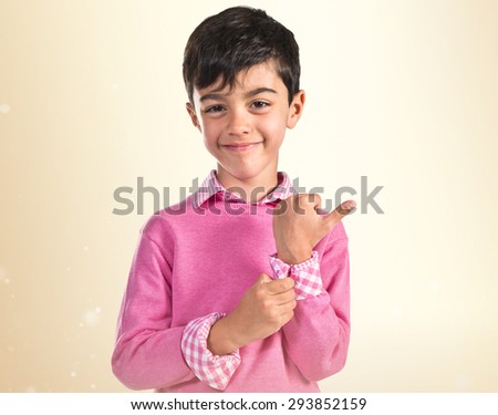 Portratit of young boy with pink sweater over ocher background