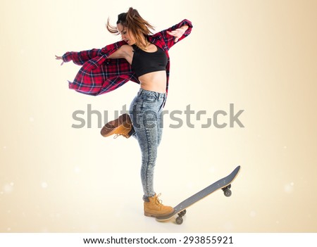 Young woman dancing with skate over ocher background
