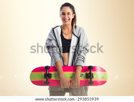 Happy woman posing with skate over ocher background