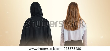 Twin sisters posing back over ocher background  