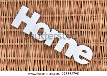 White Wood Sign Home On The Rustic Wicker Background Closeup