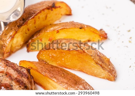 Potato wedges as a garnish for new york strip steak. Macro. Photo can be used as a whole background.