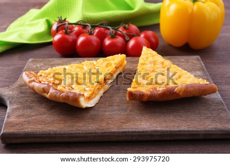 Slices of tasty cheese pizza and vegetables on table close up