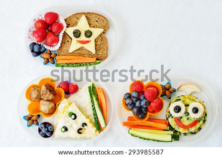 school lunch boxes for kids with food in the form of funny faces. the toning. selective focus Royalty-Free Stock Photo #293985587