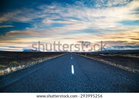 Road leading into the distance under a dramatic sky Royalty-Free Stock Photo #293995256