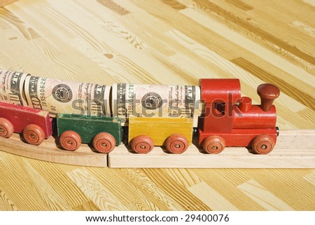A toy train pulling a cargo of money  This picture could be a reference to 'money delivery', gravy train, cargo, freight.  Also, money supply and transferring money or wiring money.